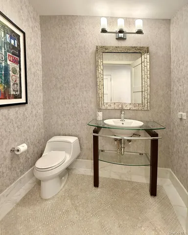 a bathroom with a toilet sink and mirror