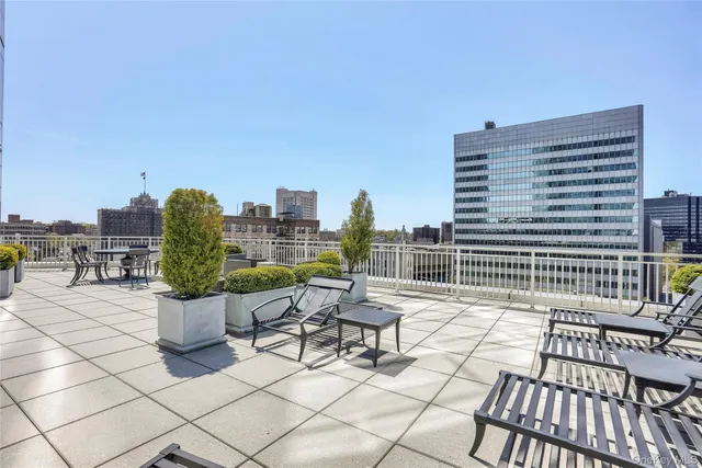 a view of roof deck with chairs and potted plants