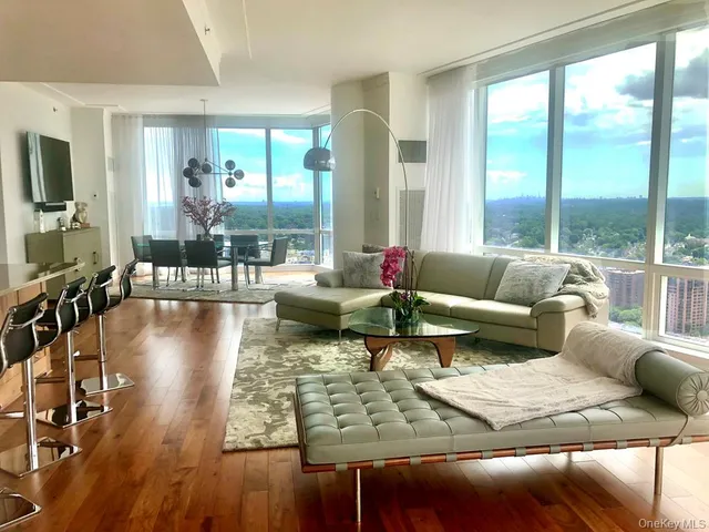 a living room with furniture wooden floor and a large window