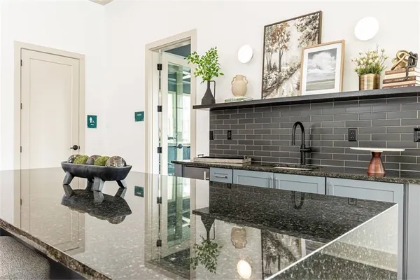 a kitchen with stainless steel appliances granite countertop a sink a stove and a wooden floors