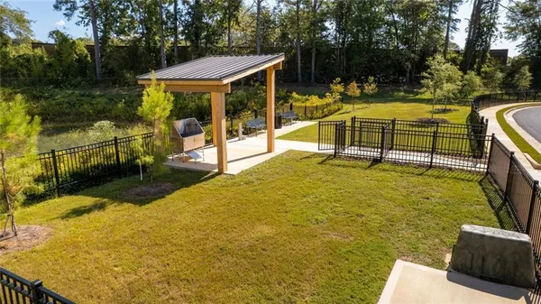 a view of a swimming pool with a patio and a yard