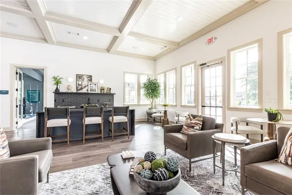 a living room with furniture potted plant and a large window