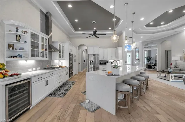 a large white kitchen with a large window and stainless steel appliances