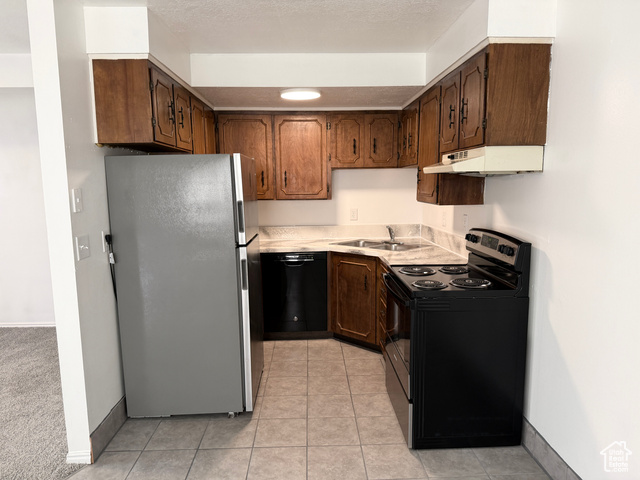 420 North 200 West Logan, UT 84321 - Photo 7 of 13 Kitchen with stainless steel appliances, light countertops, light tile patterned floors, and under cabinet range hood