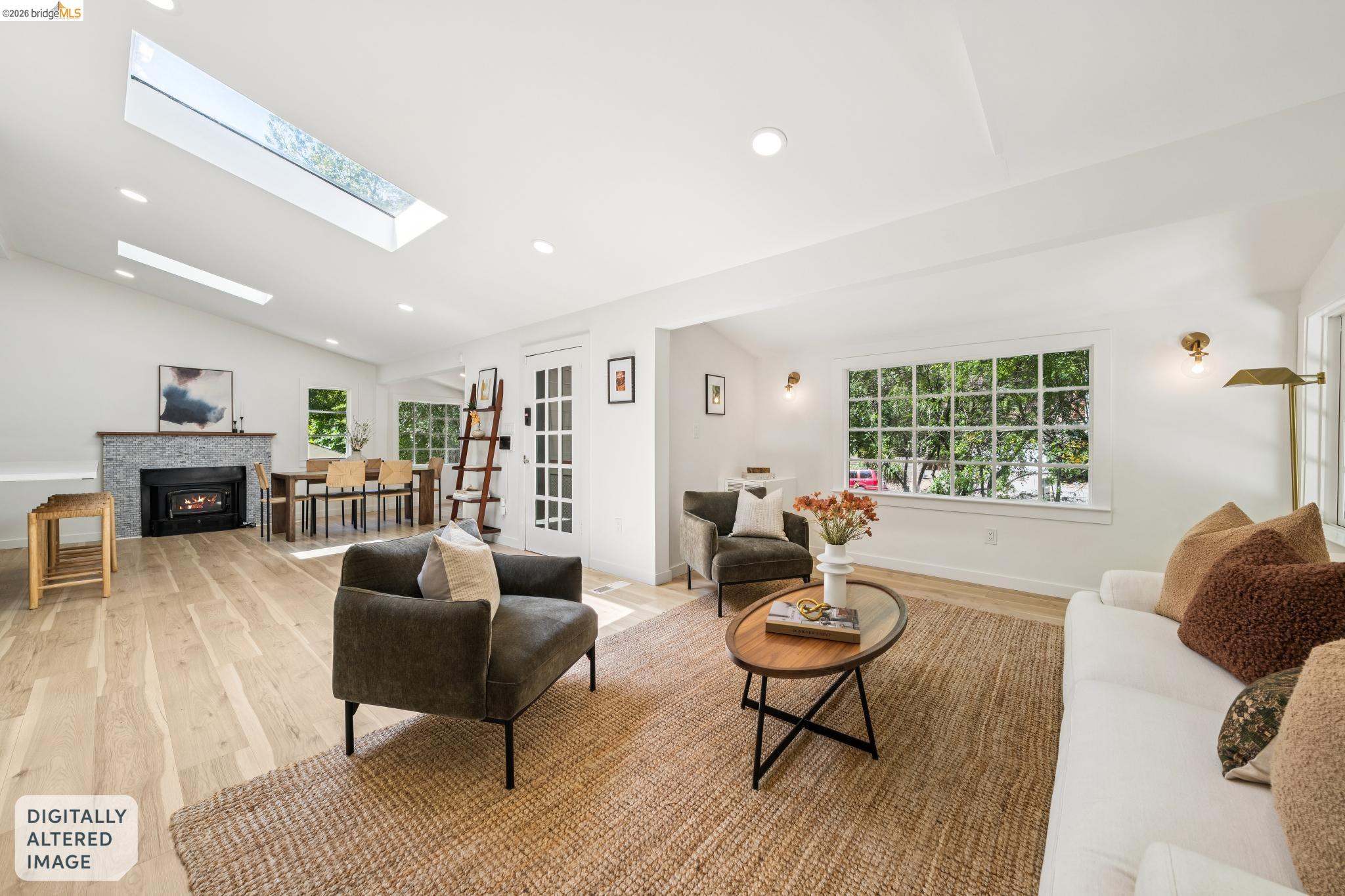 6400 Pinehaven Road Oakland, CA 94611 - Photo 12 of 78 Spacious living area featuring wood-finish flooring, a tiled fireplace with a wood mantle, and multiple skylights