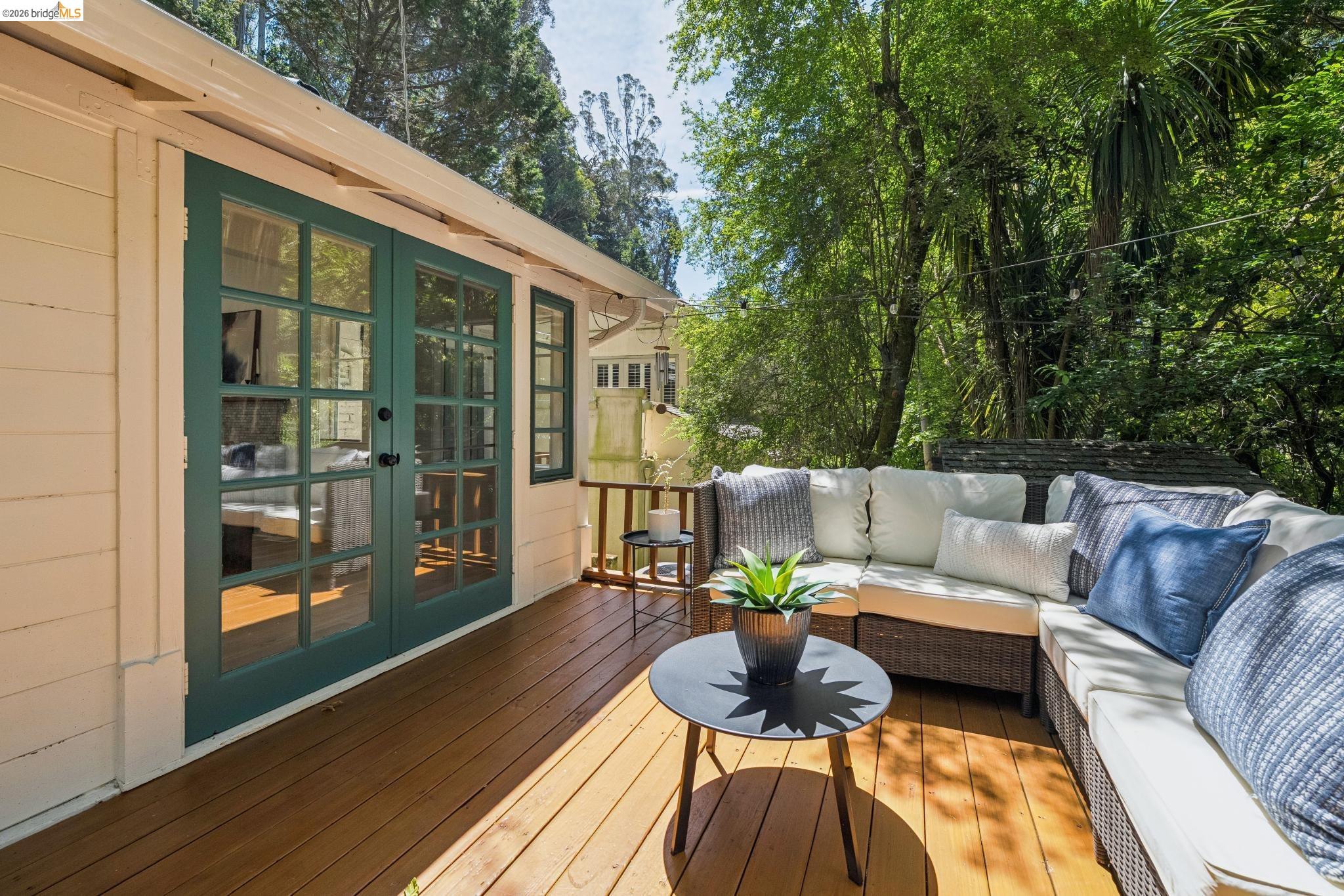 6400 Pinehaven Road Oakland, CA 94611 - Photo 32 of 78 Wood-finish deck with a cream-sided exterior and green-framed French doors