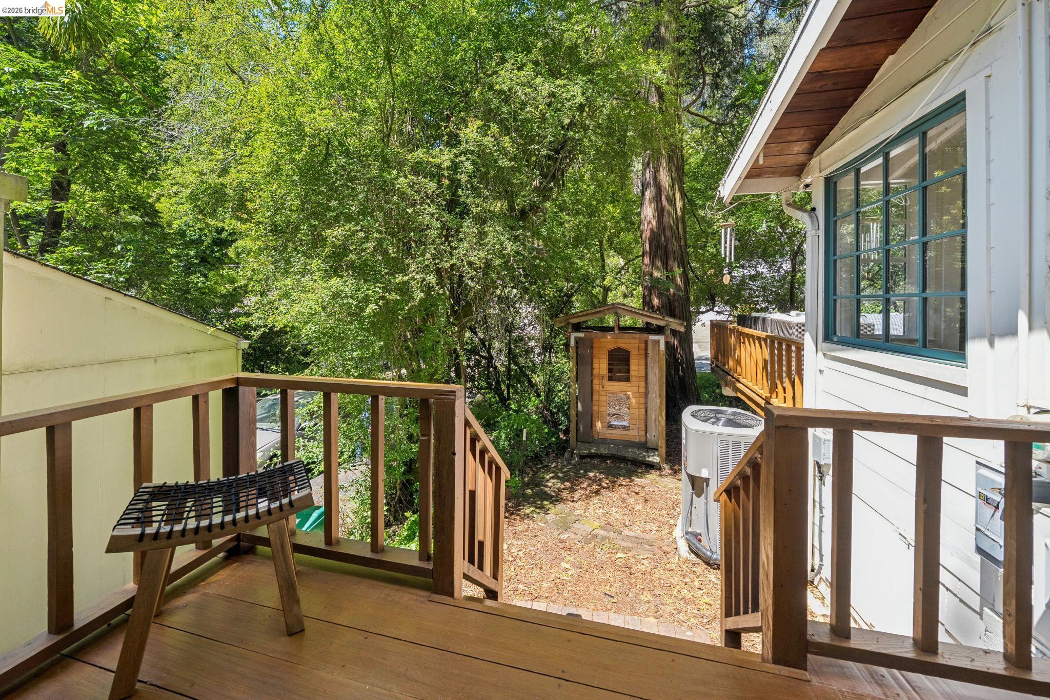 6400 Pinehaven Road Oakland, CA 94611 - Photo 36 of 78 Wood deck with natural wood railings, featuring white siding and a multi-pane window with green trim