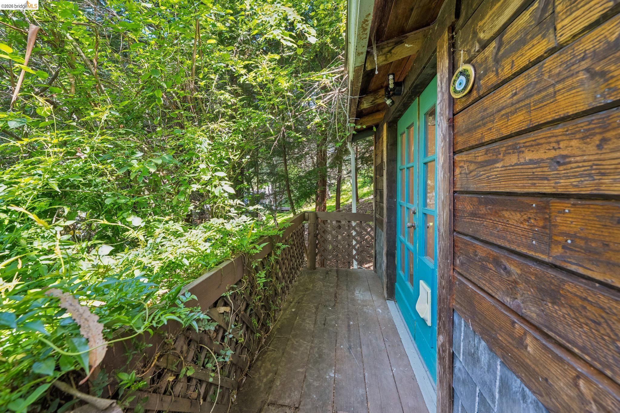 6400 Pinehaven Road Oakland, CA 94611 - Photo 56 of 78 Wood-plank siding and a vibrant turquoise door define this outdoor space