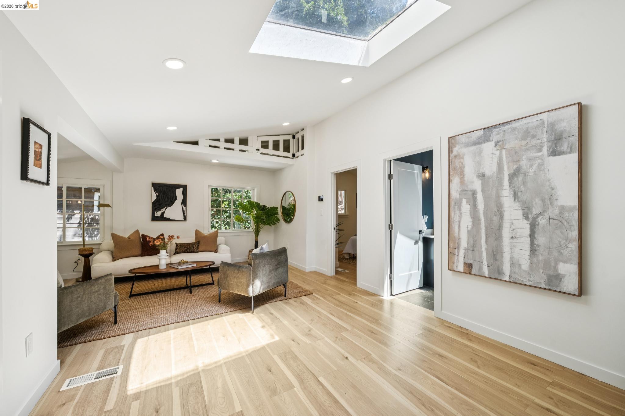 6400 Pinehaven Road Oakland, CA 94611 - Photo 6 of 78 Hardwood flooring throughout a spacious room featuring a large skylight, recessed lighting, and multiple windows