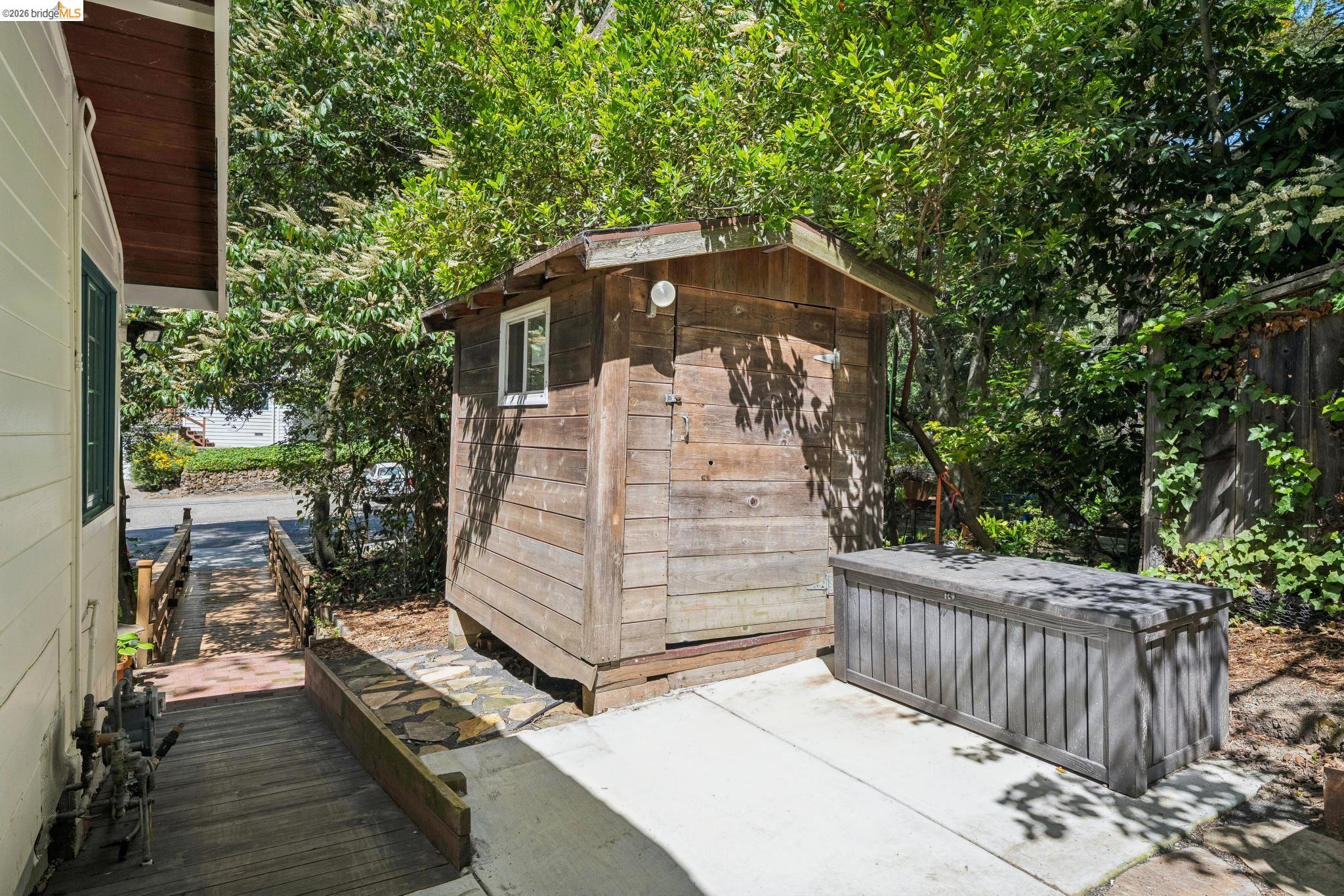 6400 Pinehaven Road Oakland, CA 94611 - Photo 65 of 78 Detached wood-sided shed with a single window, positioned on a concrete pad