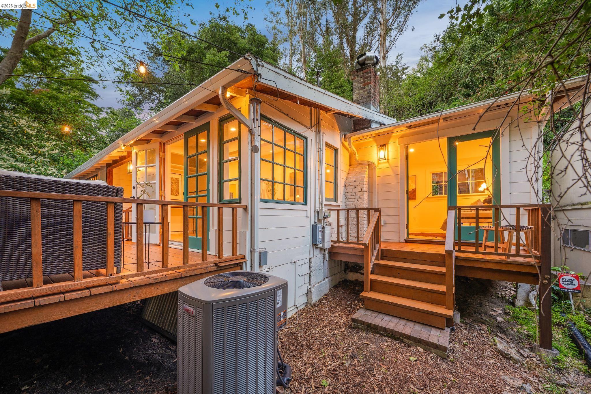 6400 Pinehaven Road Oakland, CA 94611 - Photo 67 of 78 Exterior featuring white siding, multiple decks, a brick chimney, and abundant natural light from numerous windows