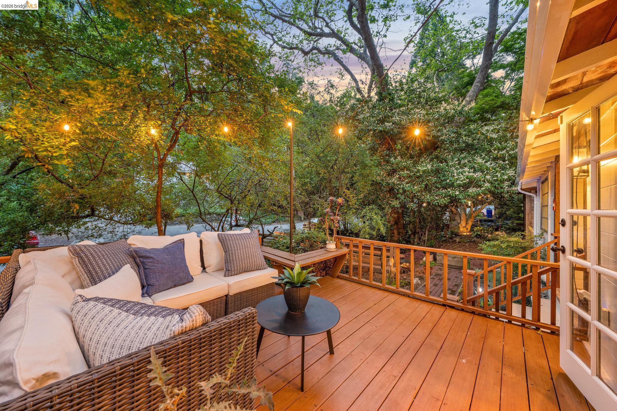 6400 Pinehaven Road Oakland, CA 94611 - Photo 69 of 78 Spacious outdoor deck featuring wood flooring, string lighting, natural wood railing, and direct access to the interior via French doors