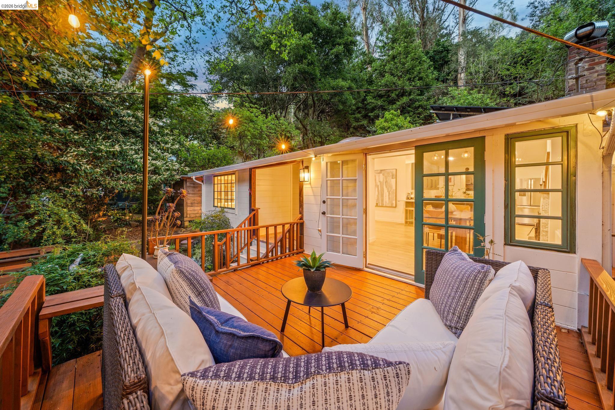 6400 Pinehaven Road Oakland, CA 94611 - Photo 70 of 78 Expansive wood deck with a built-in bench and string lighting