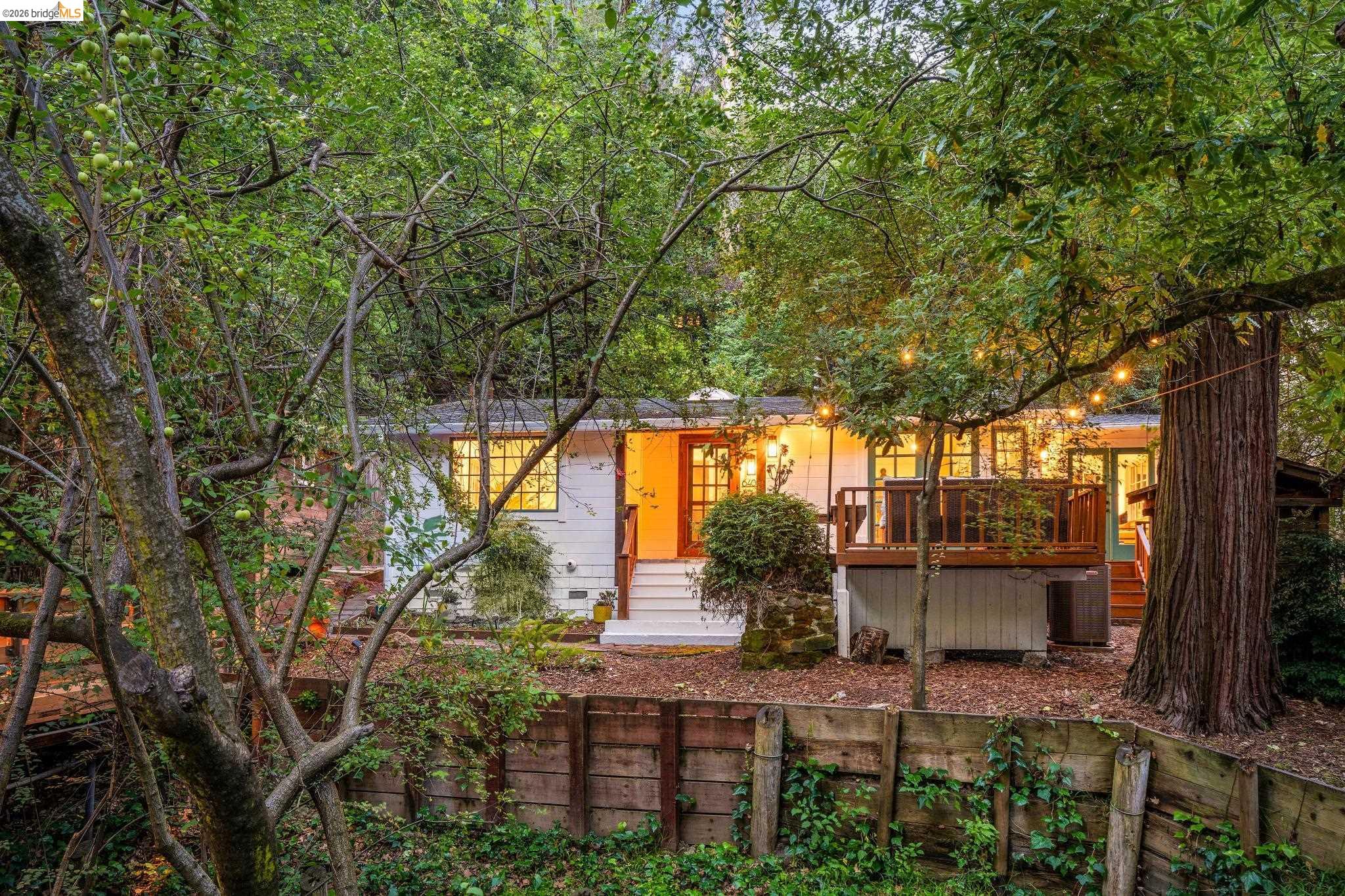 6400 Pinehaven Road Oakland, CA 94611 - Photo 77 of 78 Secluded residence surrounded by mature trees, featuring a white exterior and a wood-decked patio