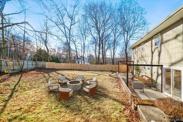 a view of a patio with couches and table and chairs with wooden floor and fence