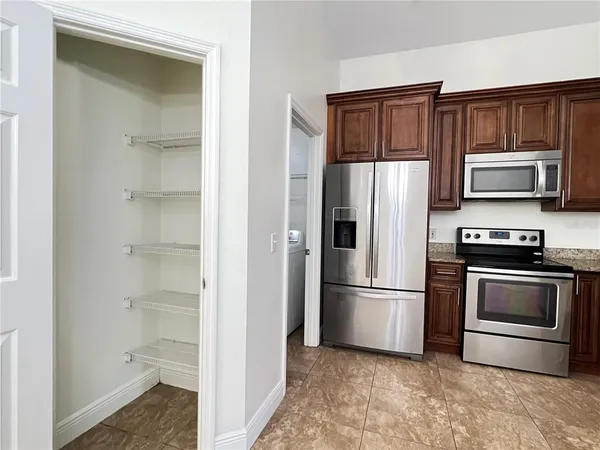 a kitchen with granite countertop a refrigerator stove and microwave