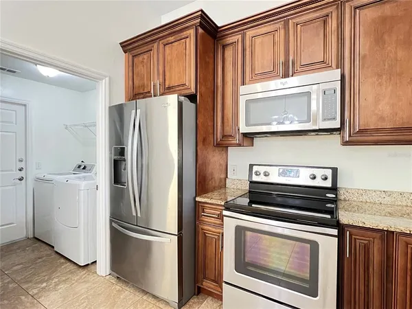 a kitchen with stainless steel appliances granite countertop a refrigerator stove and microwave