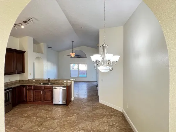 a kitchen with stainless steel appliances granite countertop a sink a stove and refrigerator