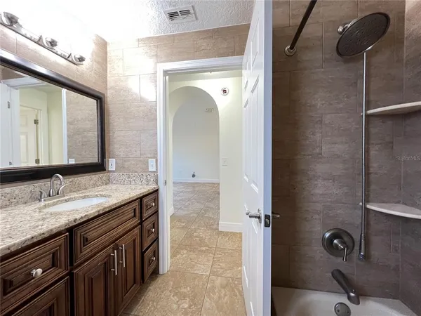 a bathroom with a granite countertop sink mirror and vanity