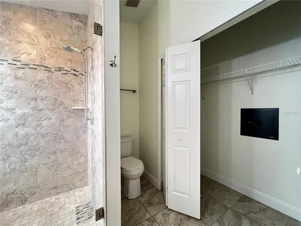 a bathroom with a toilet and a shower
