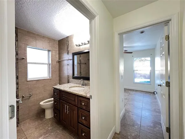 a bathroom with a granite countertop sink toilet and shower