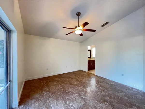 an empty room with closet and a chandelier fan