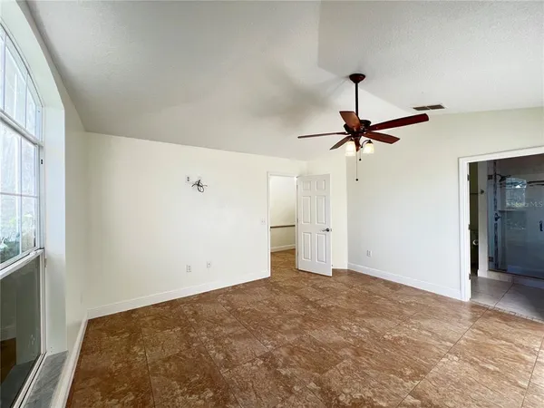 a view of a big room with closet and a chandelier fan