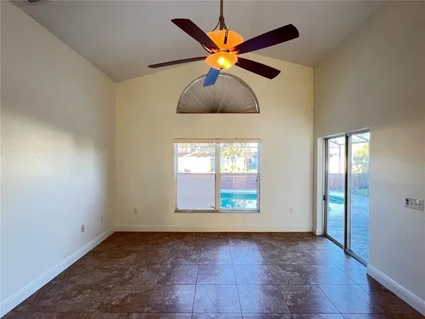 an empty room with window and ceiling fan