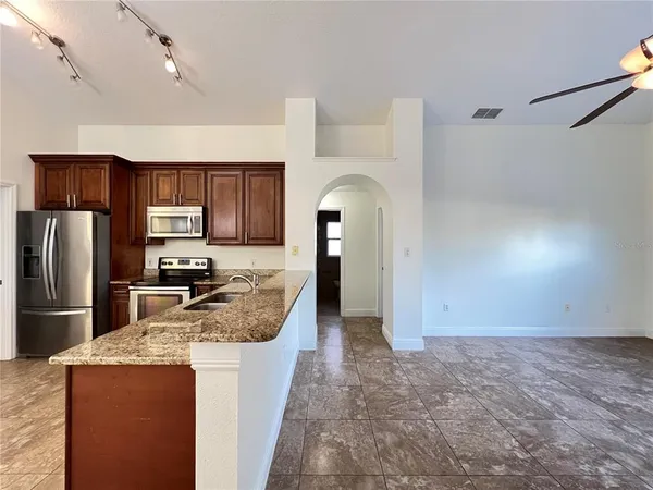 a kitchen with granite countertop a refrigerator stove and sink