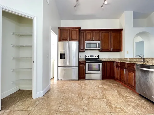 a kitchen with granite countertop a refrigerator and a stove