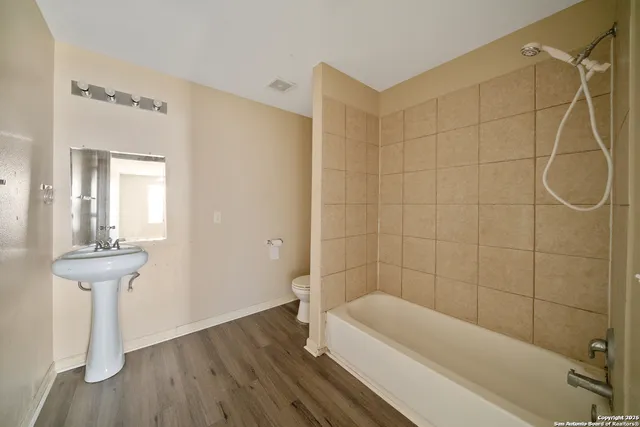 a bathroom with a sink a toilet and shower