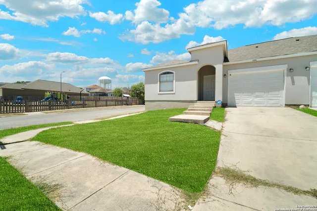 a front view of a house with a garden and patio