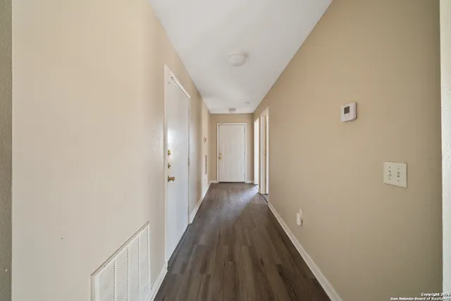a view of a hallway with wooden floor