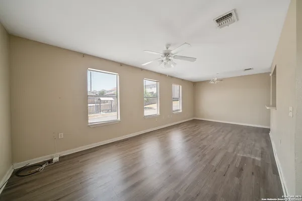 an empty room with wooden floor and window
