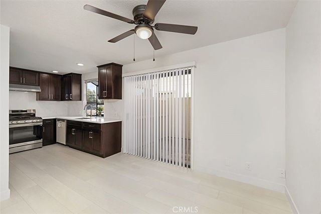 a large room with a kitchen island stainless steel appliances wooden floor and view living room