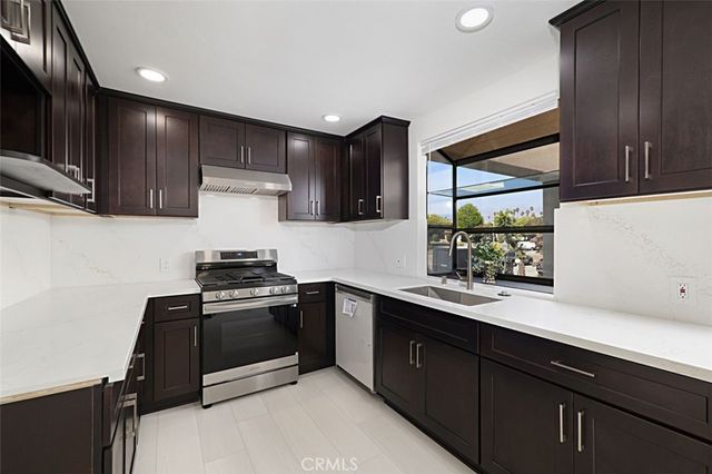 a kitchen with stainless steel appliances granite countertop a sink stove and cabinets