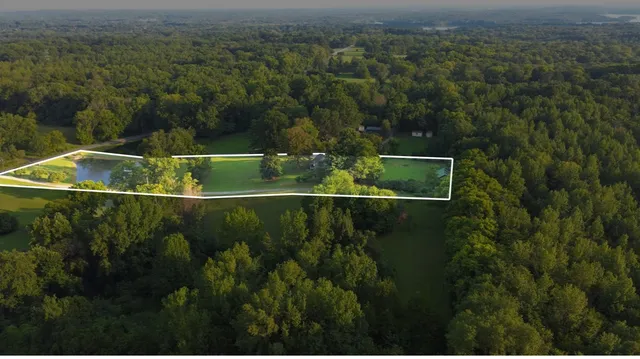 an aerial view of residential houses with outdoor space and trees
