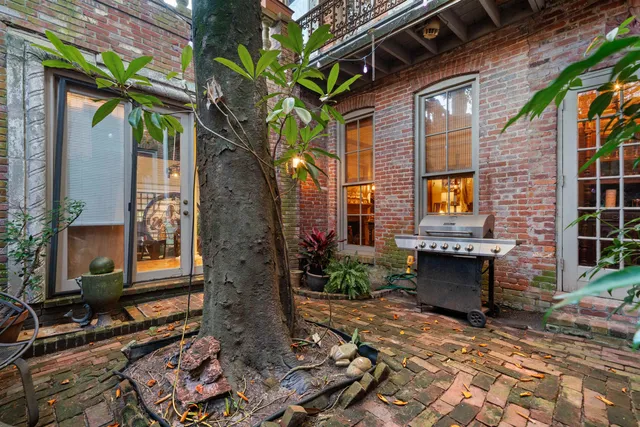 a brick building with a large tree in front