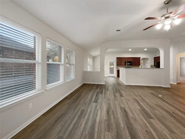 a view of a living room and a kitchen with wooden floor