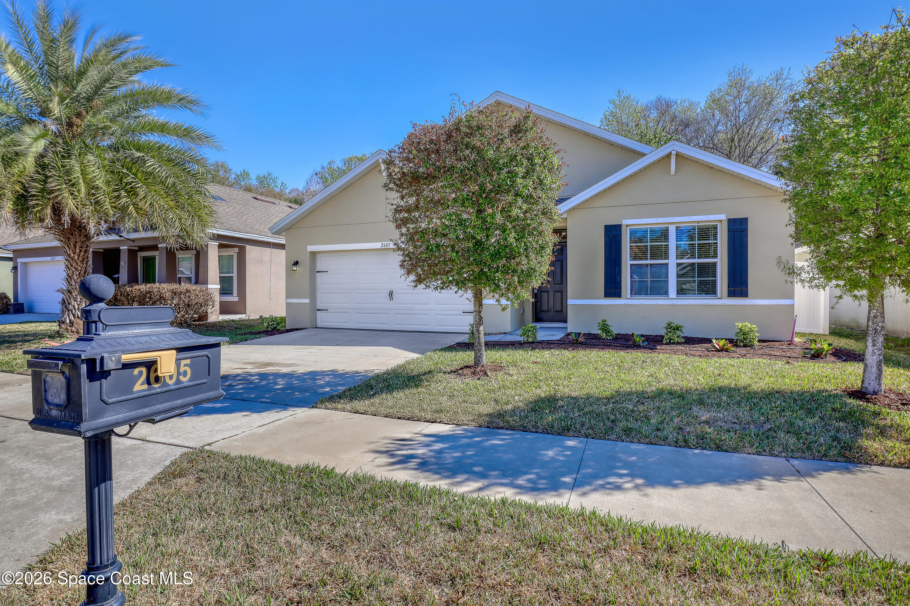 2605 Falcon Lane Mims, FL 32754 - Photo 2 of 29 a view of a yard in front of a house with plants and large tree