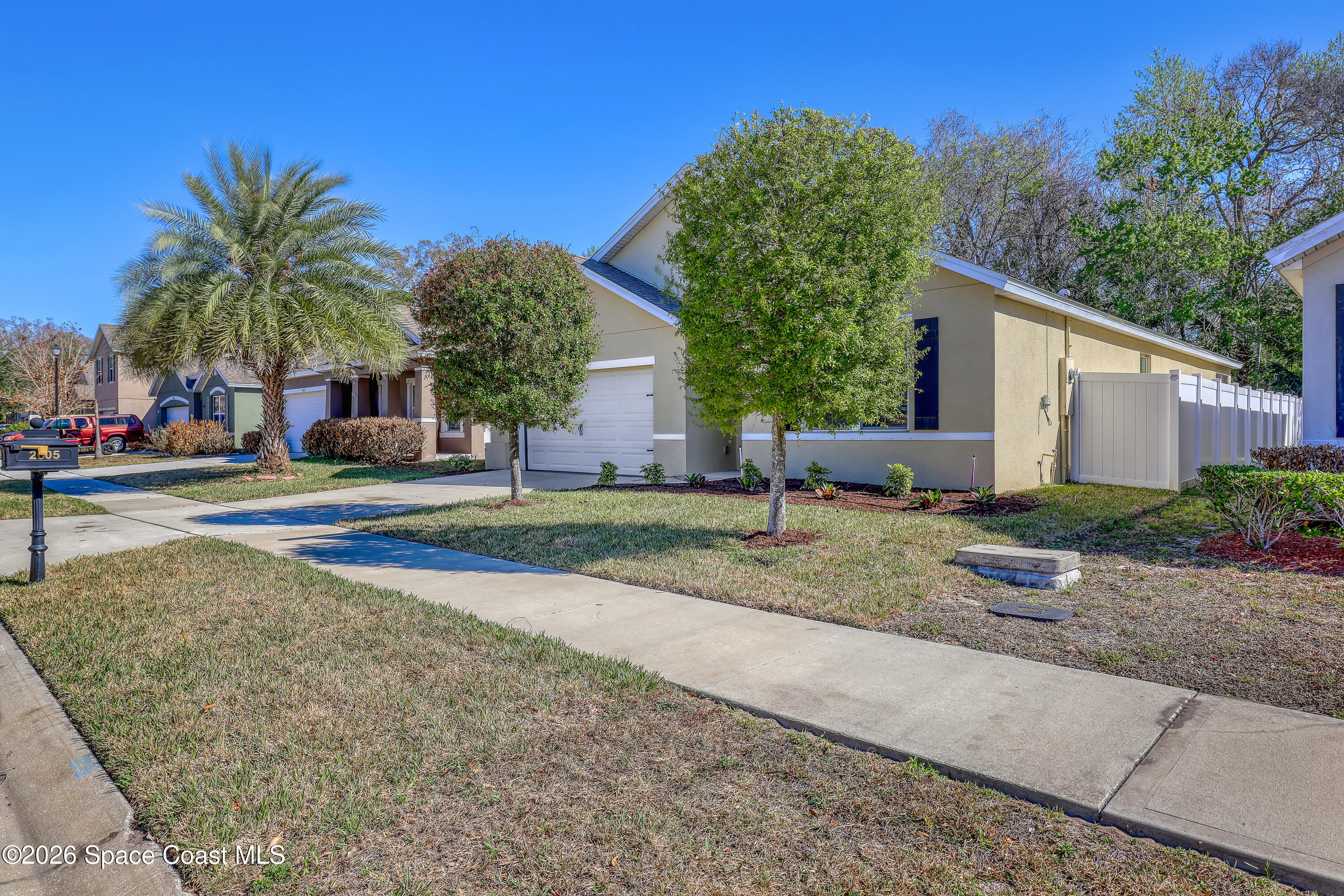 2605 Falcon Lane Mims, FL 32754 - Photo 3 of 29 a palm tree sitting in front of a house with a yard