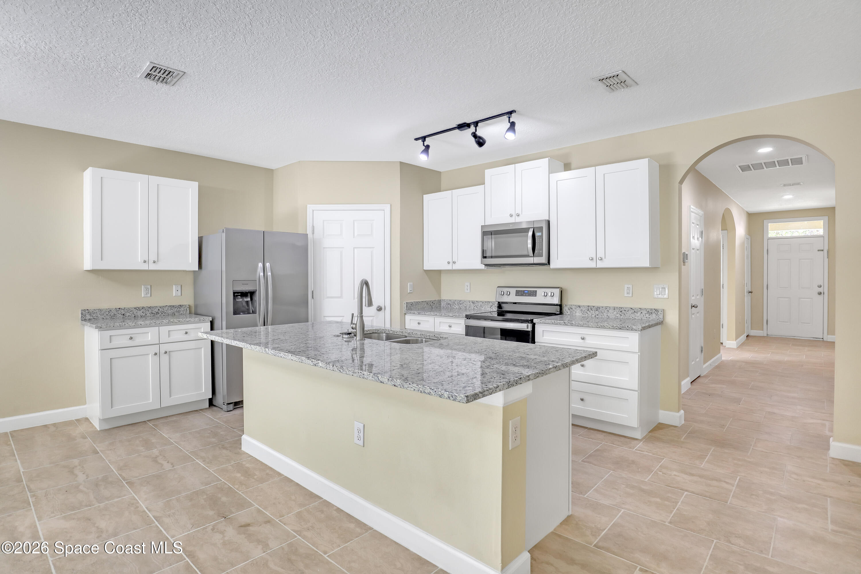 2605 Falcon Lane Mims, FL 32754 - Photo 9 of 29 a kitchen with stainless steel appliances granite countertop a sink stove and refrigerator