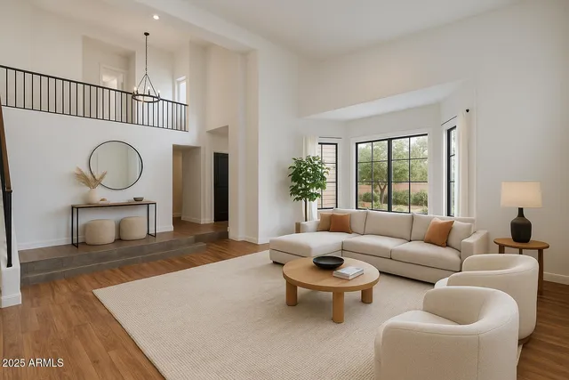a view of a livingroom and dining room with wooden floor a chandelier