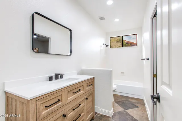 a view of empty room with wooden floor and ceiling fan