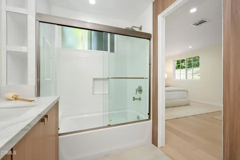 a bathroom with a shower sink and mirror