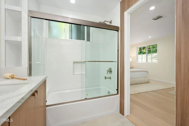 a bathroom with a shower sink and mirror