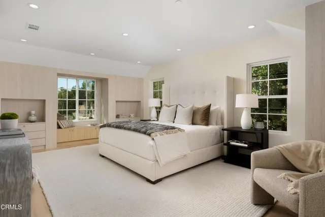 a bedroom with a bed and a large window