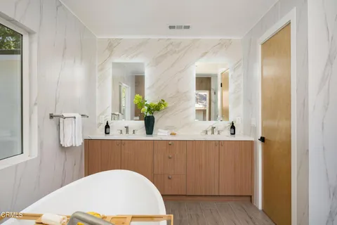 a bathroom with a granite countertop sink a mirror a toilet and shower