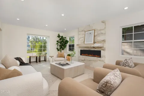 a living room with furniture large window and fireplace