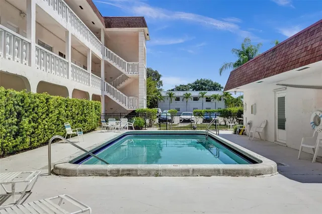 a view of a house with pool and chairs
